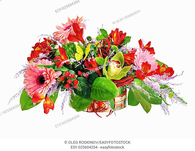 Floral arrangement from lilies, cloves and orchids in cardboard chest on white.