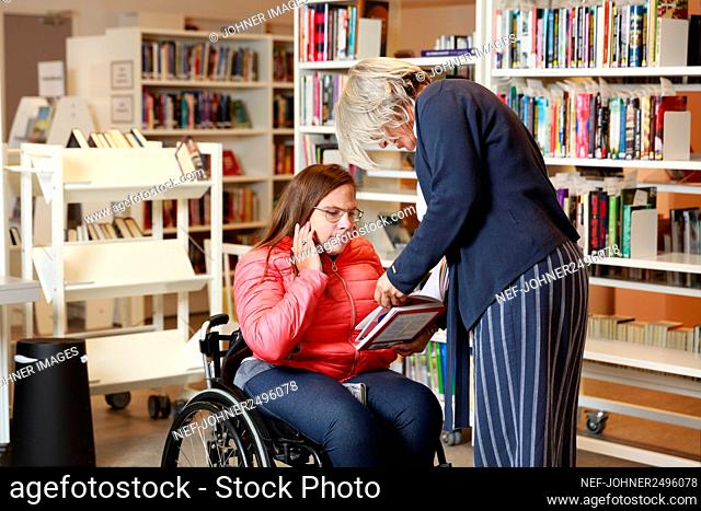 Woman on wheelchair talking to librarian