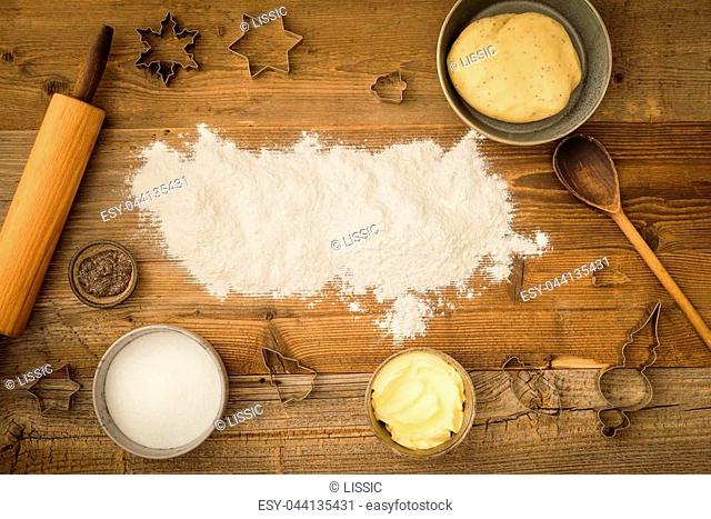 Flatlay collection of tools and ingredients for baking vegan Christmas cookies with margarine and chia seeds as egg replacement and flour copyspace on a dark...