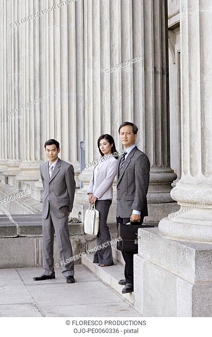 Three businesspeople outdoors on steps