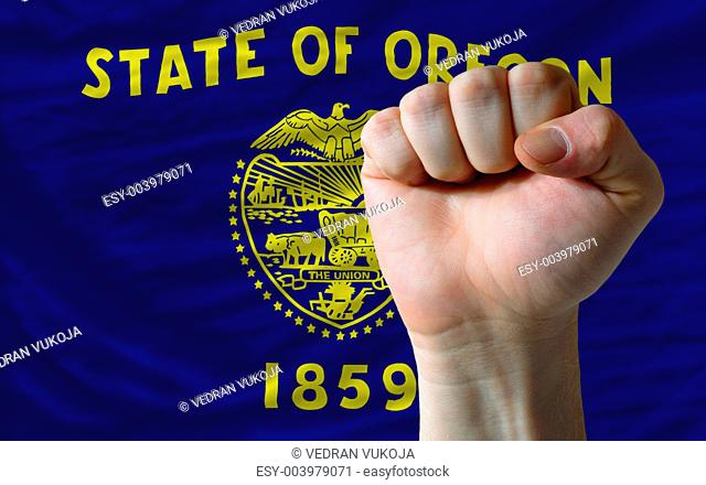 us state flag of oregon with hard fist in front of it symbolizin