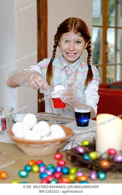 Child, girl colouring Easter eggs, Easter tradition