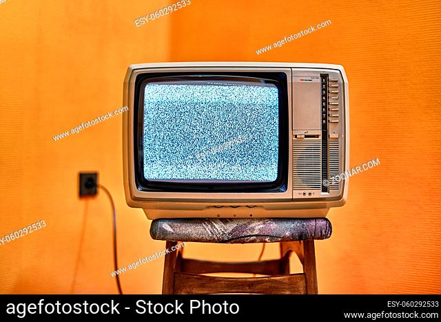 Vintage TV set on a chair in an empty room