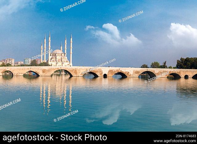 Side view of historical old stone bridge of Adana on Seyhan river, on cloudy blue sky background