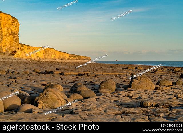 The stones and cliffs of Llantwit Major Beach in the evening sun, South Glamorgan, Wales, UK