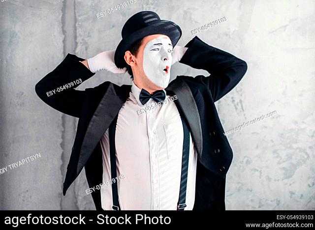 Pantomime artist with makeup mask. Mime in suit, gloves and hat. April fools day concept