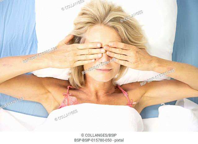 Woman rubbing her eyes in the morning