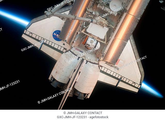 Intersecting the thin line of Earth's atmosphere, the aft section of space shuttle Atlantis is featured in this image photographed by an Expedition 23 crew...
