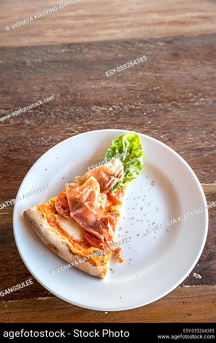 piece of pizza parma ham and rocket salad