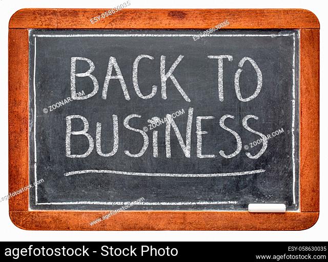 back to business - white chalk handwriting on a slate blackboard, business opening after coronavirus covid-19 pandemic and social distancing