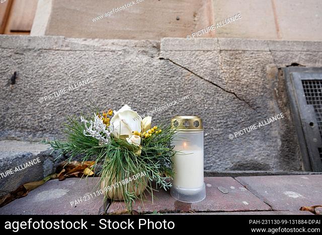 30 November 2023, Bavaria, Fürth: A grave candle and flowers stand at the birthplace of former US Secretary of State Henry Kissinger