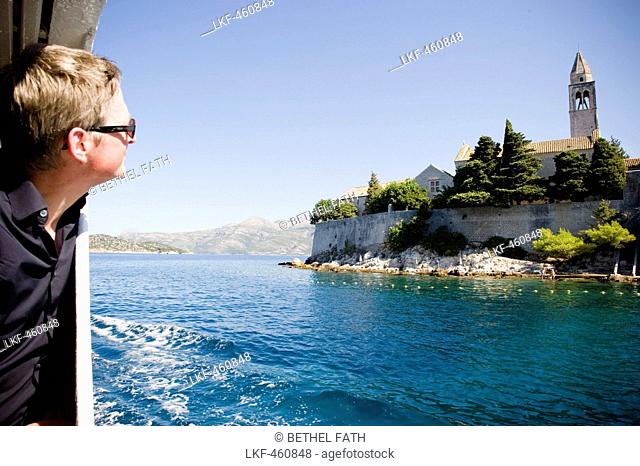 Man on a ferry looking at Franciscan monastery, Lopud, Elaphites, Dubrovnik-Neretva, Croatia