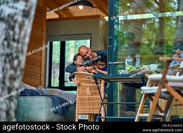 Affectionate father and kids hugging in cabin doorway