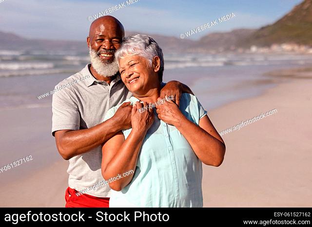 Happy senior african american couple embracing each other on the beach