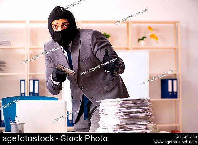 Male gangster stealing information from the office