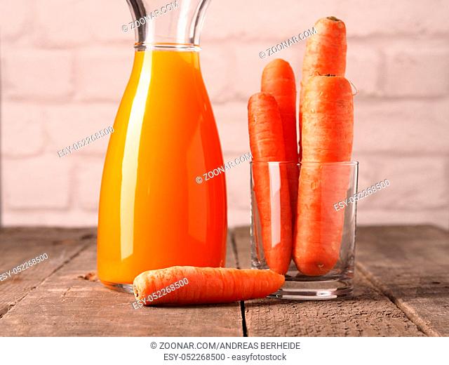 Juice of carrots with organic carrots on a wooden table, healthy food concept