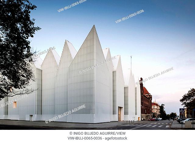 Corner elevation with zigzag roof profile against dusk sky. Szczecin Philharmonic Hall, Szczecin, Poland. Architect: Estudio Barozzi Veiga, 2014