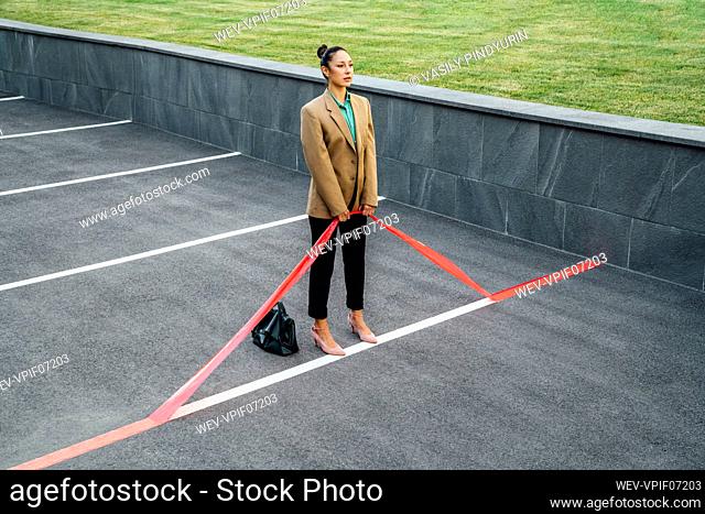 Businesswoman pulling red line at parking lot