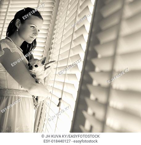 Beautiful woman and his chihuahua together in front of window