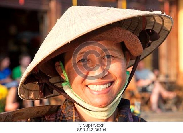 Portrait of a mature woman wearing a conical hat, Hoi An, Vietnam