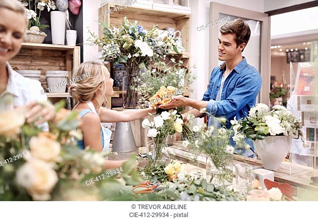 Florist giving man bouquet at flower shop