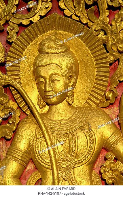 Close up of a figure carved in relif and gilded on the wood doors of the Wat Xieng Thong at Luang Prabang in Laos, Indochina, Southeast Asia, Asia