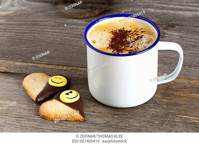 Cup of coffee and two cookies with smiley face