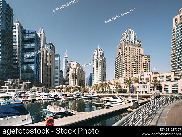 Yachts are moored at city pier, jetty in Dubai Marina. Cityscape skyline. View of glass skyscrapers in Dubai