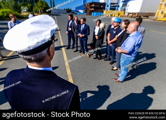 28 June 2022, Mecklenburg-Western Pomerania, Rostock: A representative of the Navy observes the photo session after the press briefing on the purchase of the...