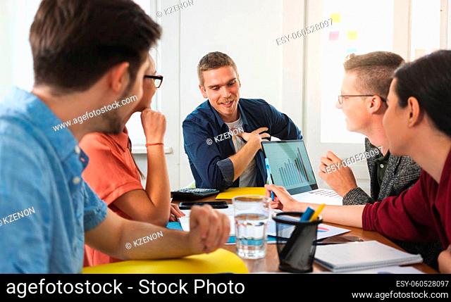 Group of happy colleagues sitting together for business planning