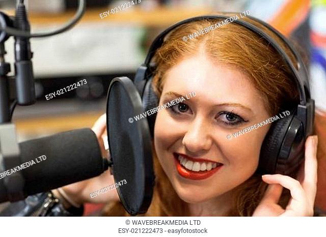 Smiling beautiful singer recording a song