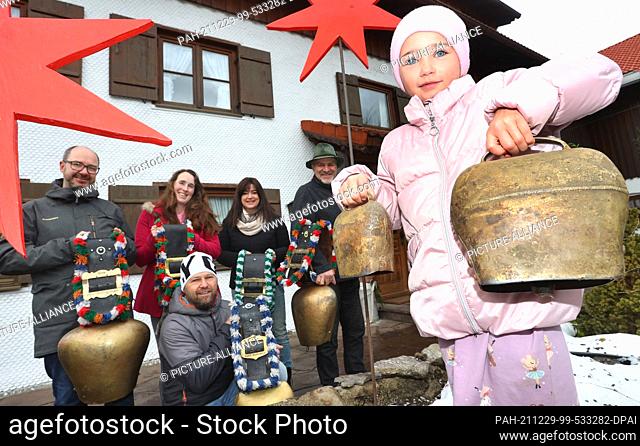 29 December 2021, Bavaria, Rettenberg: Little Lilly rings cowbells and cowbells together with the landlords Peter and Angelika Soyer (2nd and 3rd from right) as...