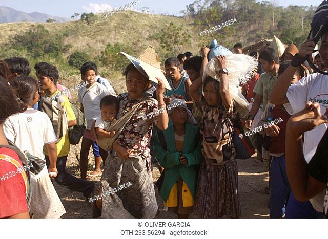 Mangyan people carrying relief goods back home, Abra de Ilog, Mindoro Province, Philippines