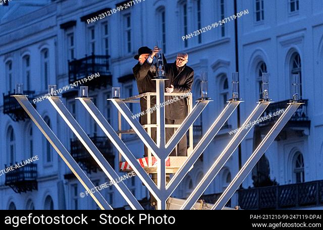 10 December 2023, Hamburg: State Rabbi Shlomo Bistritzky (l) and Peter Tschentscher (SPD), Mayor of Hamburg, light the approximately three-meter-high Hanukkah...