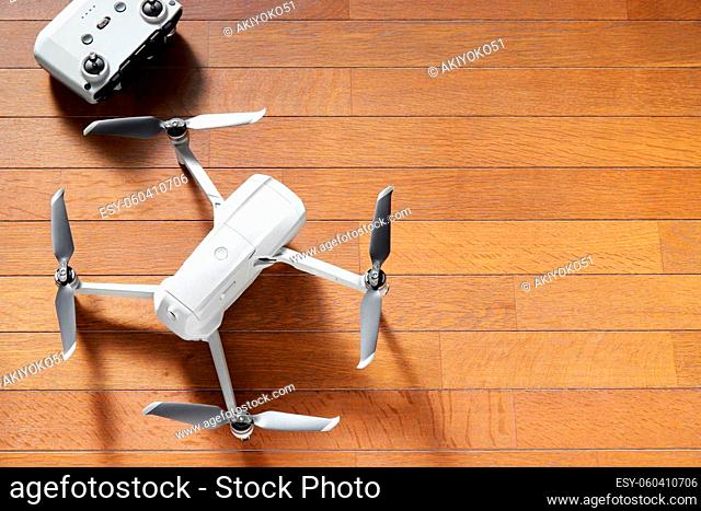 small drone copter with controller on a wooden background