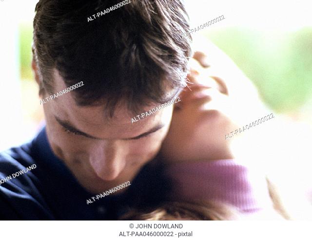 Couple embracing, close-up, blurred