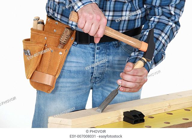 Tradesman chiseling a plank of wood