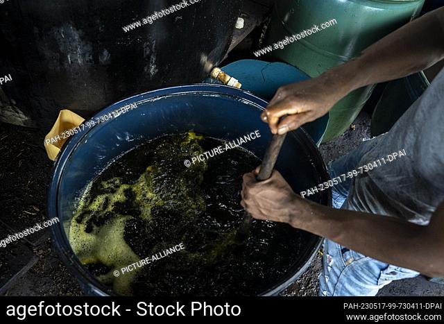 12 May 2023, Colombia, Llorente: A worker stirs a mixture of water, kerosene and sulfuric acid in a ""laboratory"" where coca leaves are processed into coca...