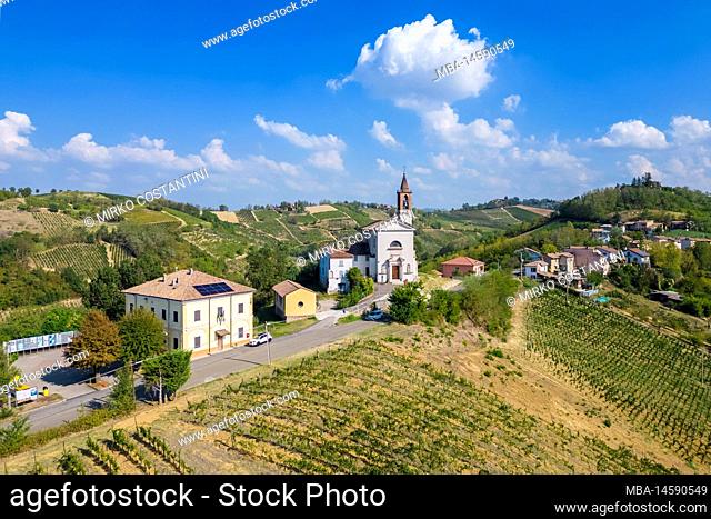 Aerial view of the church and vineyards of Corvino San Quirico. Oltrepo Pavese, Province of Pavia, Lombardy, Italy
