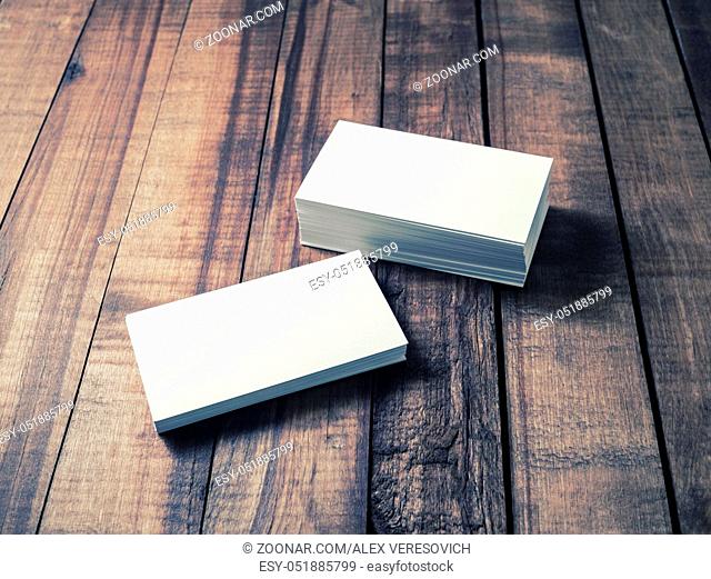 Blank business cards on wood table background. Mockup for branding identity. Studio shot