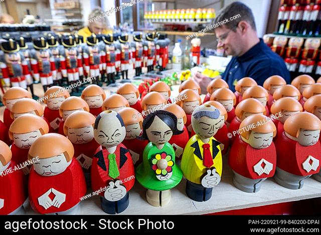 PRODUCTION - 20 September 2022, Saxony, Seiffen: Almost finished smoking figures reminiscent of the former Chancellor Angela Merkel and the current traffic...