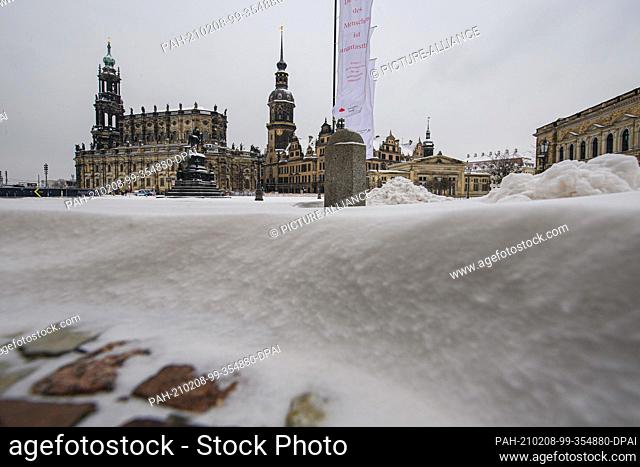 07 February 2021, Saxony, Dresden: Snow-covered is the Theaterplatz in front of the Hofkirche (l-r), the equestrian statue of King Johann, the Hausmannsturm