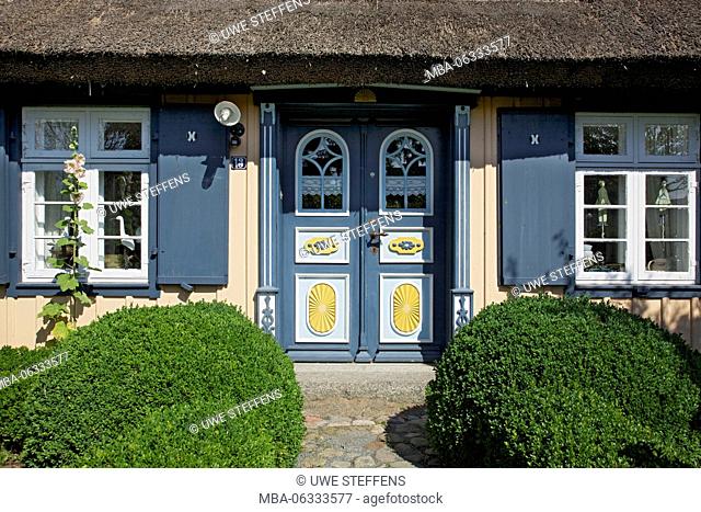 Thatched-roof house with traditional front door in Born on the Darss peninsula