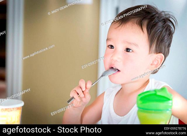 Cute Young Chinese and Caucasian Boy Enjoying Eating His Ice Cream