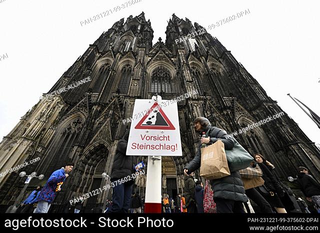 21 December 2023, North Rhine-Westphalia, Cologne: A sign in front of Cologne Cathedral warns of falling rocks. Photo: Roberto Pfeil/dpa