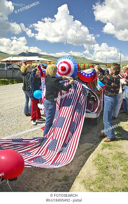 Women decorating a car in red, white & blue