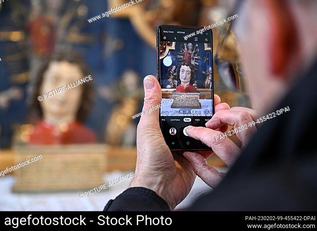 02 February 2023, Switzerland, Münsterlingen: Architect and historian Bertet Hugo photographs the bust of St. John, which stands on a side altar in the...