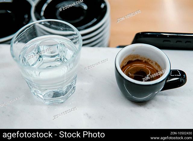 cup with coffee near a glass of water on the table
