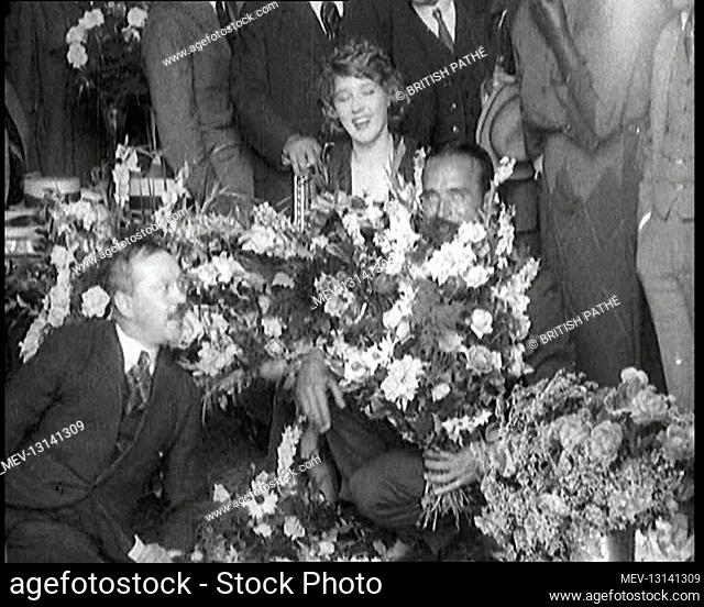 Mary Pickford and Douglas Fairbanks Senior Sitting Together Amongst A Bed Of Flowers In Paris. Douglas Is Smelling the Flowers - Paris