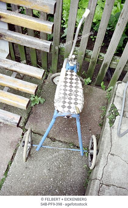 Dreirad neben einer Holzbank - Gemuesebeet - Garten - Nostalgie - Spielzeug , Three Wheeler next to a wooden Bench - Vegetable Patch - Garden - Nostalgia - Toy